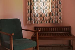 a green chair and a bench in a room at KothiPushkar in Pushkar