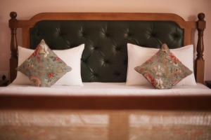 a bed with two pillows and a green headboard at KothiPushkar in Pushkar