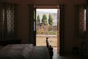 a bedroom with a bed and a door with a window at KothiPushkar in Pushkar