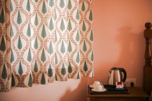 a tea kettle on a table with a curtain at KothiPushkar in Pushkar