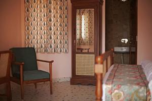 a bedroom with a bed and a chair and a window at KothiPushkar in Pushkar