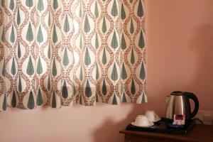 a pair of curtains on a wall next to a table at KothiPushkar in Pushkar