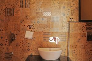 a bathroom with a sink and a mosaic wall at KothiPushkar in Pushkar