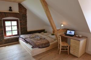 Schlafzimmer mit einem Bett und einem Schreibtisch mit einem Laptop in der Unterkunft Yogashrama traditional in Ústí nad Orlicí
