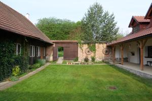 a backyard of a house with a green lawn at Yogashrama traditional in Ústí nad Orlicí