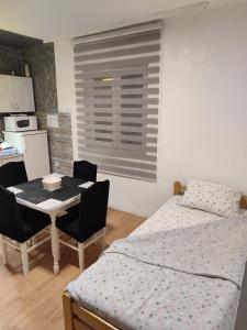 ein Schlafzimmer mit einem Bett und einem Tisch und Stühlen in der Unterkunft Kuršumlijska banja apartman in Kursumlijska Banja