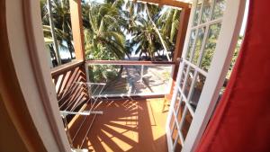 an open door to a balcony with a table and palm trees at Southern Haven Cabin in Laborie
