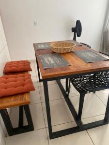 a table and a chair with a basket on it at Apartamento em Ilhéus próximo as Praias in Ilhéus