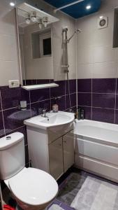 a bathroom with a toilet and a sink and a tub at Residence Apartments Deva in Deva