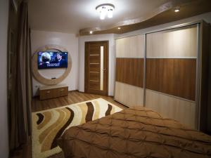 a bedroom with a bed and a mirror and a television at Residence Apartments Deva in Deva