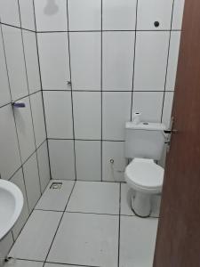 ein weißes Bad mit einem WC und einem Waschbecken in der Unterkunft Sitio in Itapoa