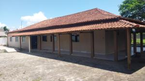 ein kleines Gebäude mit einem gefliesten Dach in der Unterkunft Sitio in Itapoa