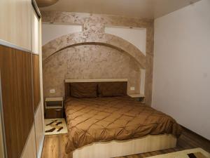 a bedroom with a bed with a stone wall at Residence Apartments Deva in Deva