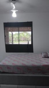 Schlafzimmer mit einem großen Bett und einem Fenster in der Unterkunft Sitio in Itapoa