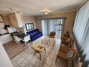 a living room with a blue couch and chairs at SurfBay Sands 65 in Shelly Beach