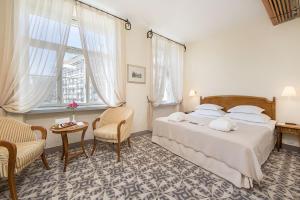 - une chambre avec un lit, une table et des chaises dans l'établissement Rixwell Collection Savoy Boutique Hotel, à Tallinn