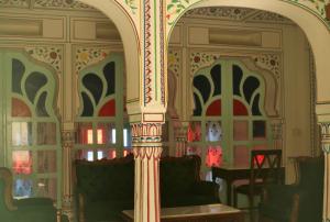 an archway in a room with chairs and a table at KothiPushkar in Pushkar