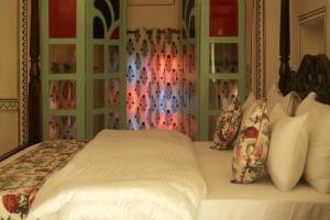 a bed with white sheets and pillows in a bedroom at KothiPushkar in Pushkar