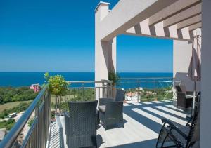 a balcony with chairs and a view of the ocean at Minna Apartments in Utjeha
