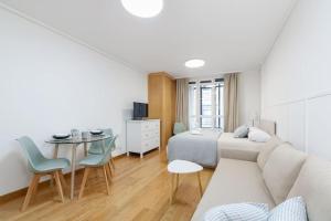 a bedroom with a bed and a couch and a table at Céntrico y acogedor by CABANA Rentals in Vigo