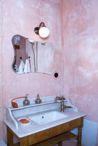 une salle de bain avec un lavabo et un miroir dans l'établissement Anassa Townhouse, In Rethymno's old city center, à Réthymnon 44 autres photos