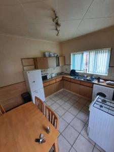 een kleine keuken met een tafel en een koelkast bij Basic 5-bedroom home - Affordable accommodation for groups in Swansea