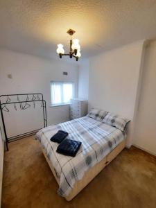 een slaapkamer met een bed met 2 kussens erop bij Basic 5-bedroom home - Affordable accommodation for groups in Swansea