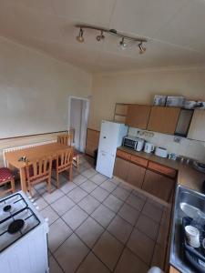 een keuken met een tafel en een tafel en een keuken met een tafel bij Basic 5-bedroom home - Affordable accommodation for groups in Swansea