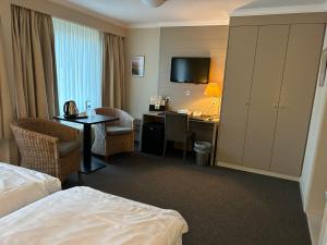 ein Hotelzimmer mit einem Bett und einem Schreibtisch mit einem Computer in der Unterkunft Hotel Atlas in Zeebrugge