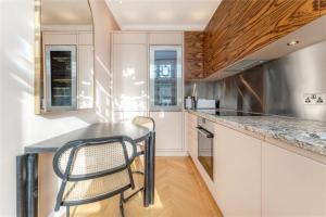 eine Küche mit weißen Schränken sowie einem schwarzen Tisch und Stühlen in der Unterkunft Marble Arch £2.6million apartment sleeps up to 6 in London