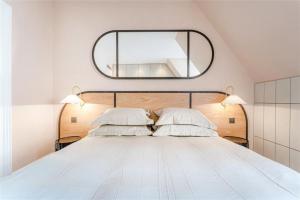 ein Schlafzimmer mit einem großen weißen Bett und einem großen Spiegel in der Unterkunft Marble Arch £2.6million apartment sleeps up to 6 in London