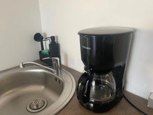 a coffee maker sitting on a counter next to a sink at Tiny House Lily with jacuzzi in Sveti Filip i Jakov