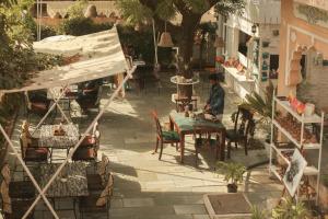 una persona seduta a un tavolo in un patio di KothiPushkar a Pushkar