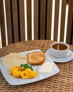 einen Teller Eier und Toast und eine Tasse Kaffee in der Unterkunft Balmoral Plaza Hotel in Pereira