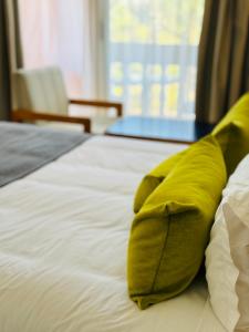 almohada verde sobre la cama en Hotel Idou Tiznit en Tiznit
