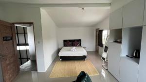 - une chambre blanche avec un lit dans l'établissement Kampoeng Saya, à Seminyak