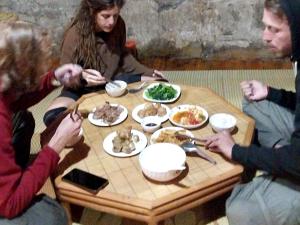 een groep mensen die rond een tafel eten bij Trieu Hoan homestay in Cao Bằng