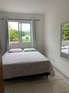 um quarto com uma cama e uma janela em Apartamento em Ilhéus próximo as Praias em Ilhéus