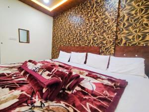 een slaapkamer met een bed met een rode deken erop bij junagadh places in Ujjain