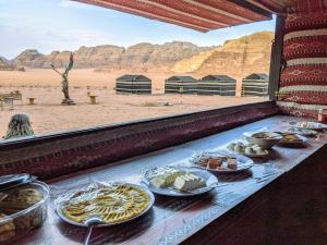 un buffet de plats sur une table dans le désert dans l'établissement Wadi rum galaxy camp, à Wadi Rum