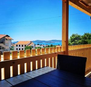 a wooden deck with a table on a balcony at Tiny House Lily with jacuzzi in Sveti Filip i Jakov