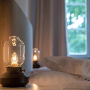 a glass jar on a bed with a window at Au Major Davel in Cully