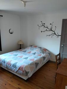 a bedroom with a bed with a tree on the wall at Appartement Vesonne in Vésonne