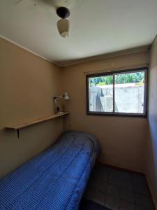 a small bedroom with a bed and a window at Departamento en el centro in Lago Puelo
