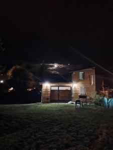 una casa por la noche con un banco delante en Cabaña Bigua en San Martín de los Andes