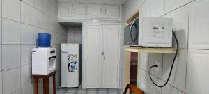 a kitchen with a microwave oven and a refrigerator at Pousada Palmeira in Viracopos
