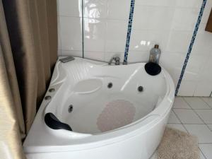a white bath tub sitting in a bathroom at TR GUEST HOUSE in Matola