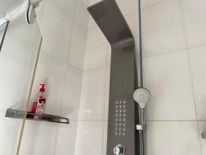 a shower with a shower head and a shower at TR GUEST HOUSE in Matola