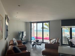 una sala de estar con sofás y vistas al océano. en Luxury Beach Villa, Praia de Chaves, Boa Vista en Boa Ventura