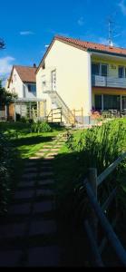 uma casa com uma cerca em frente a um quintal em Ferienwohnungen Seereif und Seeklein em Immenstaad am Bodensee